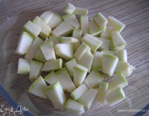 Кабачки нарезать кусочками, половину порции уложить в смазанную маслом форму для запекания. Присолить.