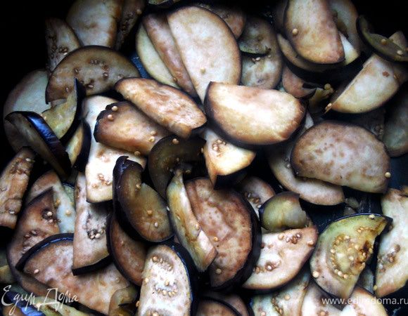 Баклажаны нарезать, обжарить на сухой сковороде на сильном огне, помешивая, 3-4 минуты. Затем огонь убавить, добавить немного масла и воды (несколько ложек), накрыть крышкой - баклажаны хорошо "пропарятся", а самое главное, для этого способа требуется минимум масла. При необходимости в процессе добавить еще немного воды, в целом готовить еще около 5 минут. Баклажаны отложить.