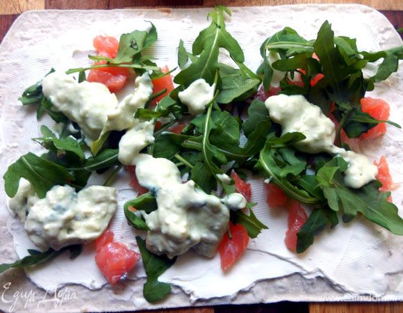 Основу смазать сыром, поверх эстетично разбросать рыбу, руколу и кусочки авокадо ***если авокадо чрезвычайно спелый, как у меня, можно размять, слединить с мятой (или другой зеленью) и йогуртом. Свернуть рулетом и наслаждаться:)