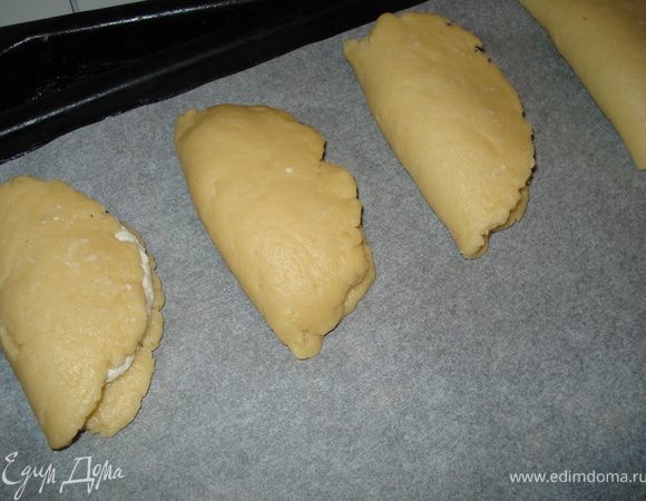 Разложить на застеленный бумагой для выпечки противень. К желтку добавить немножко молокa, взбить и смазать сочники.