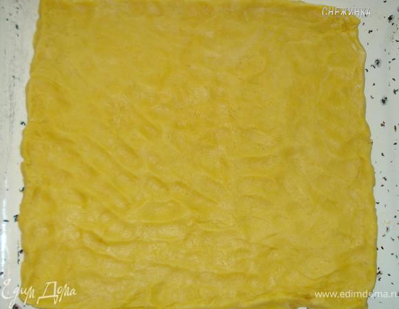 Одну часть теста (которая меньше) надо положить в холод (я кладу в морозильник, так тесто лучше потом натирается), другую (которая больше) – раскатать на противень, толщина теста зависит от Вашего вкуса, если хотите больше теста и меньше начинки, то раскатывайте не очень тонко, но тогда и количество пирожных будет меньше :-).