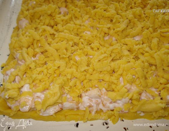 Начинку распределяем на раскатанное тесто, тесто из морозильника натираем на крупной тёрке поверх начинки. 