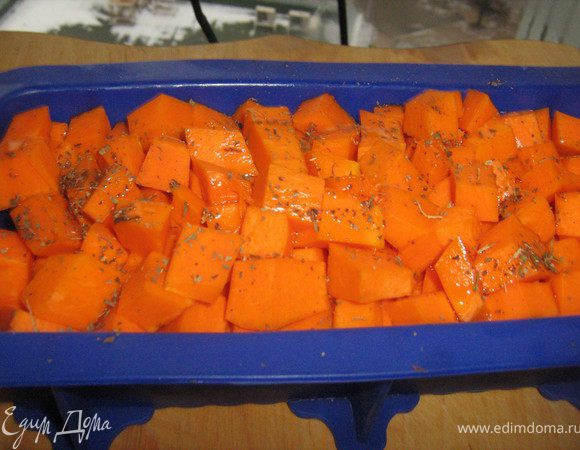 сверху на бекон положить очищенную и нарезанную кубиками тыкву,полить оливковым маслом и посыпать базиликом.Запекать в духовке 25-30 минут.Духовку не выключать.Дать тыкве не много остыть.