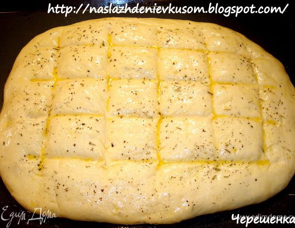 После того как вы придали фокачче задуманную форму, выкладываем ее на противень, смазанный растительным маслом, опять затягиваем пленкой и ставим на расстойку на 40 минут… Теперь берем палочку (у меня для суши) или просто пальчиками делаем углубления в тесте для того, чтобы когда мы фокаччу смазываем оливковым маслом, оно у нас не убежало, а задержалось в этих ямках…