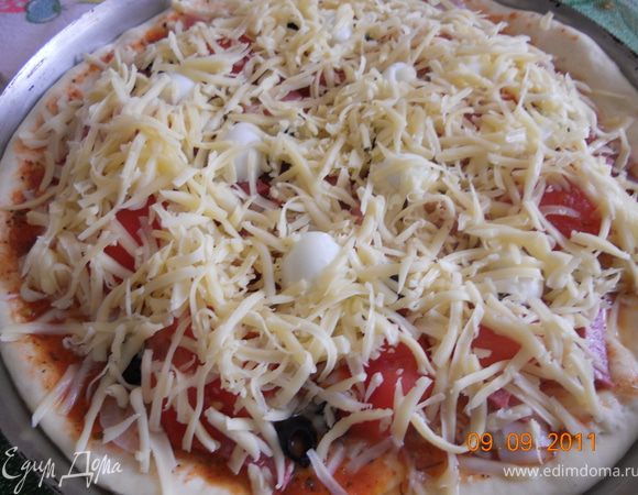 тесто раскатываем выкладываем на противень, поливаем соусом, сверху лук порезанный полукольцами, бекон мелко порубленный, колбасу соломкой,помидор дольками, оливки кружками, яйца режем пополам и укладываем по кругу, посыпаем сыром и в духовку на 30 мин при 200 гр