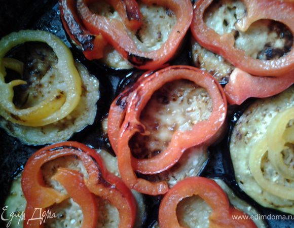 Выложить баклажаны одним слоем на противень, на них сверху колечки перца. 