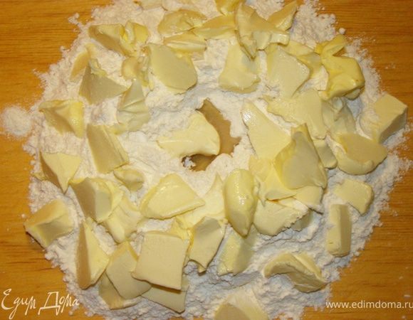 Насыпать на доску муку горкой, сделать в ней углубление, влить в него растительное масло, положить маленькими кусочками сливочное масло, посолить.
