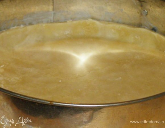Раскатать тесто в скалкой в пласт толщиной 1/2 см и уложить в круглую форму диаметром 25-35 см.