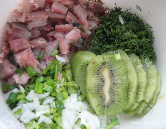 Сельдь очистить от кожи и костей,разобрать на филе и нарезать кусочками,зелёный лук и укроп мелко нарезать ,киви очистить,нарезать дольками.Сложить все продукты в подходящую чашку и измельчить с помощью блендера
