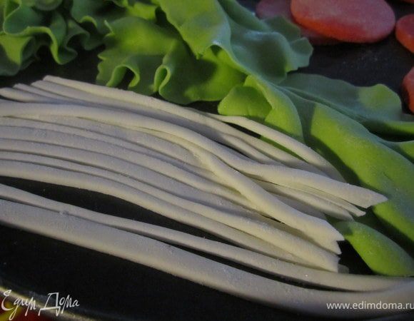 Из белой мастики вырезать тоненькие полосочки.