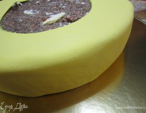 Аккуратно тоненьким ножом, тупым концом, мастику подвернуть под низ торта.