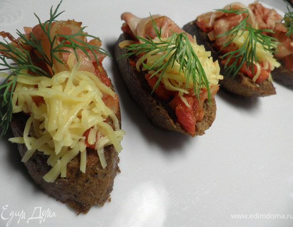 На чесночные гренки выкладываем помидоры,приправить по вкусу специями.
Бекон нарезать на полоски и выложить на помидоры с одной стороны,с другой посыпаем натёртым сыром.
Приятного аппетита!

