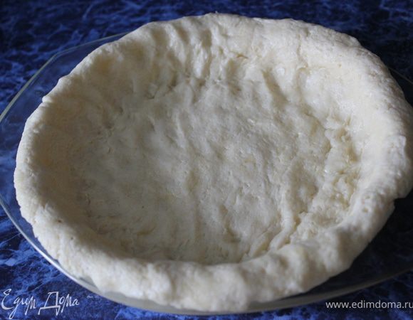 Собираем наш пирог. В стеклянную форму выкладываем наше тесто. Прижимаем его плотно и создаем бортики.