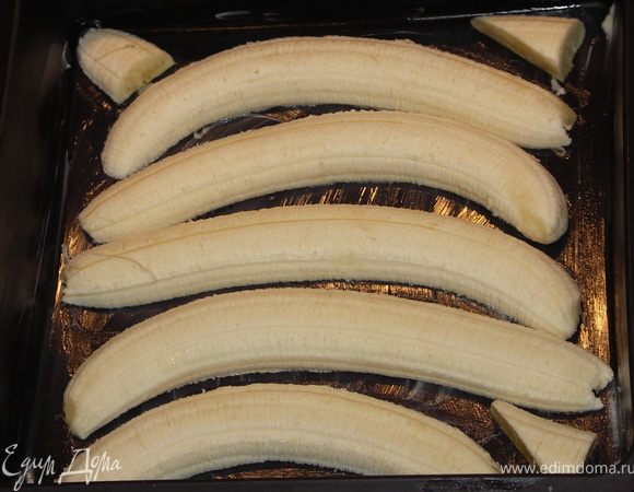 В форму смазанную сливочным маслом выложить бананы разрезанные пополам.