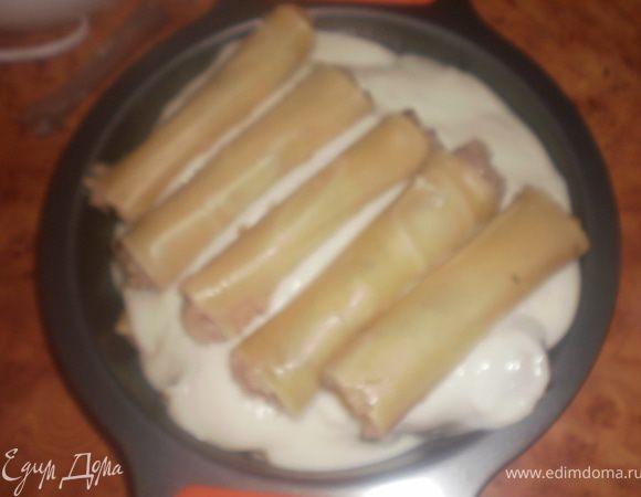 Выложить каннелони в форму, залить соусом. Если все не поместились, выложить второй слой, полить соусом.