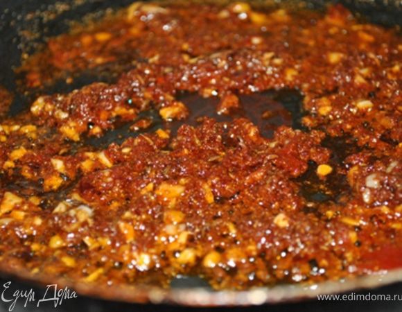 Хорошо разогреть масло. Всыпать специи, чеснок, томатную пасту и помешивая жарить 30 секунд.
