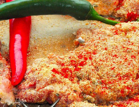 Делаем шницели. Пока овощи в духовке сделаем шницели. Подготовленные куски мяса сначала обвалять во взбитом яйце, а затем в молотых сухарях. Запанированные шницели посыпать сладкой паприкой. Теперь можно включать плиту и разогревать сковородку.