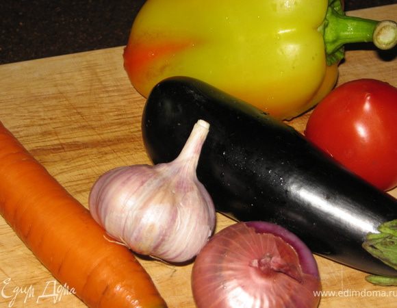 Включить духовку на 200 град.  На противень выложить фольгу. На нее положить баклажаны и перцы. Запекать по 10 минут с каждой стороны, пока овощи не станут мягкими. Затем перцы горячими кладем в целлофановый пакет на 10 минут. После чего легко очищаем от семян и кожуры.Баклажаны ополаскиваем холодной водой и тоже очищаем от кожуры. Овощи режем на небольшие кусочки.