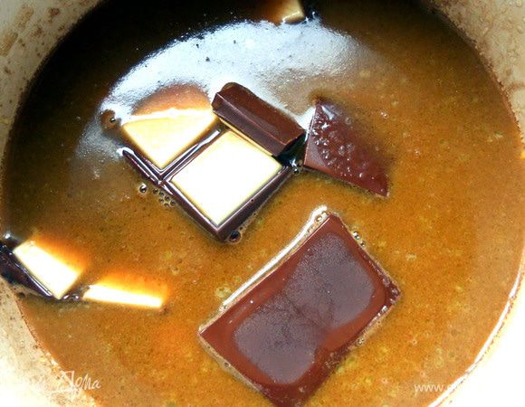 Присоединить поломанный шоколад, растопить, помешивая, до однородности массы. Снять с огня, немного охладить.