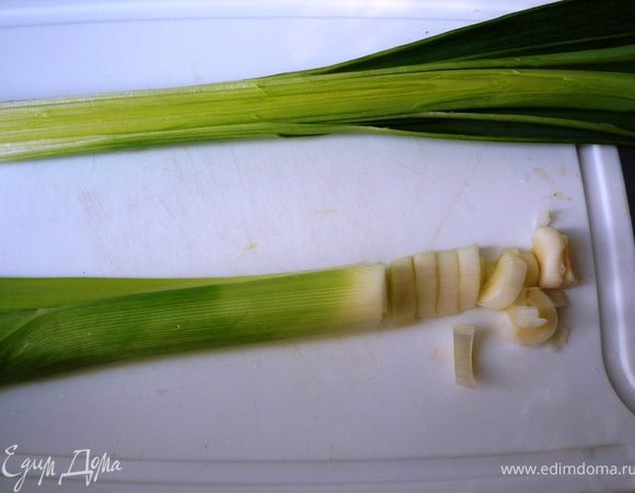 Тем временем лук-порей разрезать вдоль на 2 части и основательно промыть. Нарезать полукольцами.