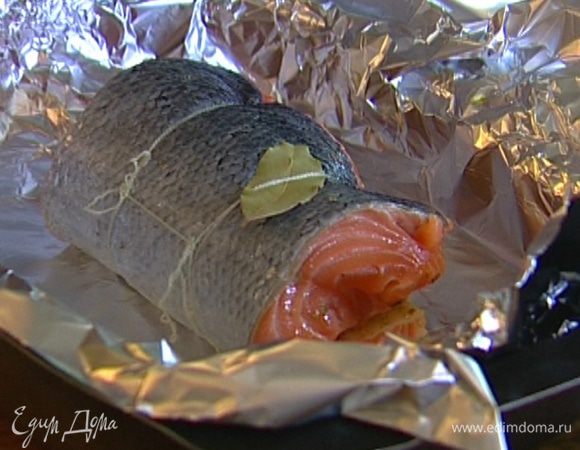 Выложить рулет на противень, лавровые листья подсунуть под нить и прикрыть рыбу краями фольги.