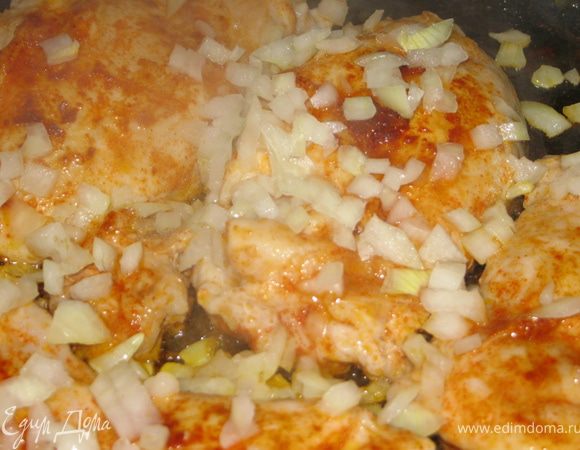 Убавляем огонь до минимума, выкладываем на мясо мелко порезанный лук. накрываем крышкой.