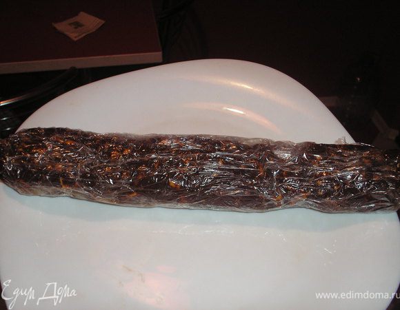 Добавить печенье, хорошо вымесить, сформировать на пишевой пленке полено, придать форму колбасы. Обернуть пленкой и поставить на несколько часов в холодильник.