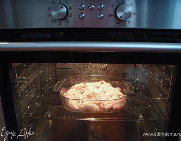 Залить соусом крылышки и поставить в разогретую до 220 градусов духовку.