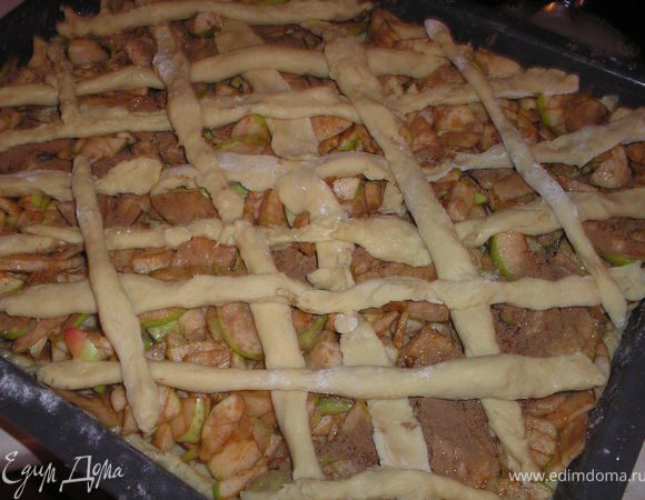 Винимаем тесто из холодильника, делим на две части, одну чуть большу, другая чуть меньше. На смазаный протвинь выкладываем большую часть теста, сверху яблоки, посыпаем несколькими ложками сахара (по вкусу) и корицей. Из другой части теста раскатываем длинные полоски и выкладываем сверху яблок в форме решетки. Отправляем в духовку на 40-50 мин при температуре 180-200 градусов.