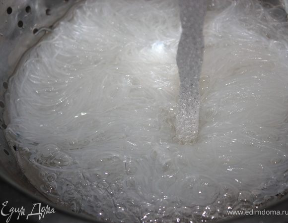 Тем временем фунчозу промыть под холодной водой и слить на дуршлаг.