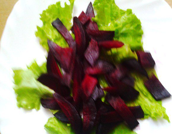 Свеклу отварить, нарезать ломтиками. Выложить на салат. 