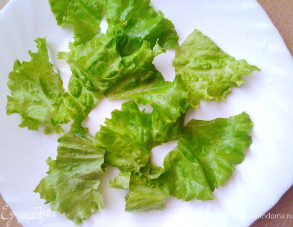 Листья салата помыть, высушить и порвать на дно салатницы.
