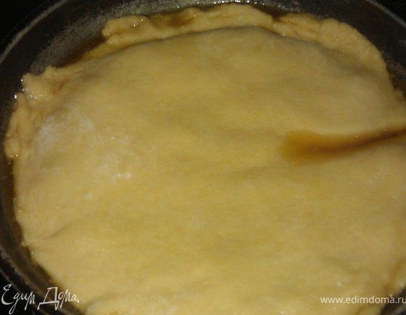 Достаём тесто из холодильника и раскатываем пласт диаметром чуть больше сковороды. Накладываем сверху на начинку, подтыкая края.