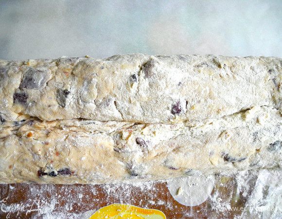 Затем придать форму штоллена. С обеих сторон закатать края, теста. Я сделала равные рулетики с обеих сторон, но лучше с одной стороны сделать меньше, с другой больше. Затем немного примять тесто с одной стороны. 