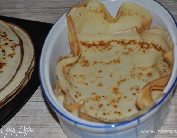 Форму для запекания смазать маслом, застелить дно и стенки блинами