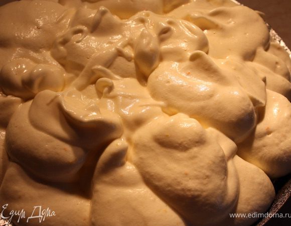 Через 40 мин от начала выпечки уменьшить температуру духовки до 150 С, достать пирог, снять фольгу. Прямо на горячие фрукты ложкой выложить суфле.