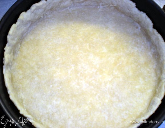 Охлаждённое тесто раскатать в круглую лепёшку и выложить в форму для выпечки.На дно положить лист бумаги и насыпать сухую фасоль или горох,чтобы корж не поднялся во время выпекания.Выпекать в разогретой духовке (200гр) 15-20 минут.