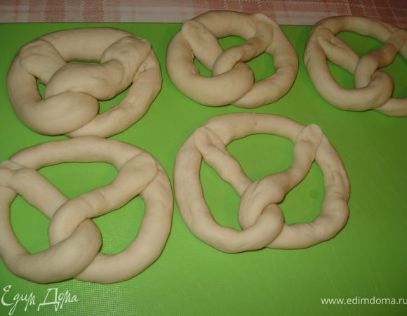 Когда тесто поднимется, то его коротко подмесить и разделить на 12 одинаковых частей.
 С каждого кусочка сделать тонкую колбаску, длиной примерно 60 см, в середине она должна быть толще
 и сформировать брецель. Духовку прогреть на 200°С.
 Для лаугэ воду довести до кипения и добавить соду. Температуру сбавить и осторожно отпускать в горячую лауге по одной брецель. Брецель должна находится в лауге 30-60 секунд.