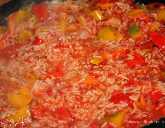 Всыпать рис, залить томатным соком и тушить до готовности риса на медленном огне. 