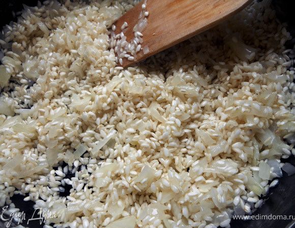 Добавить рис, перемешать. Влить вино и дать ему выпариться на достаточно сильном огне, минуту-две.