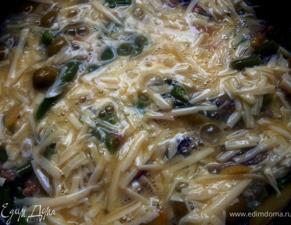 Сразу же залить смесью из слегка взбитых яиц с частью сыра, соли, перца. Готовить на умеренном огне, можно под крышкой, пока яйца не схватятся, минут 7-10.