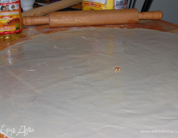 Отдохнувшее тесто делим на две части. Так легче будет раскатывать и выпекать. Получится два рулета. По очереди тесто раскатываем тонко,без фанатизма)).Смазываем его обильно маслом.