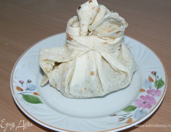 В это время Один лаваш нарезать на ленты, ими будем завязать остальные лаваши.
Другой лаваш нарежьте на порционные квадраты
В лаваш добавить начинку.
Лаваш завернуть и завязать.