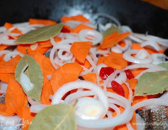 В посуду(кастрюля,сотейник,жаровня) с толстым дном положите рыбу,затем переслоите овощи и лавровый лист.
