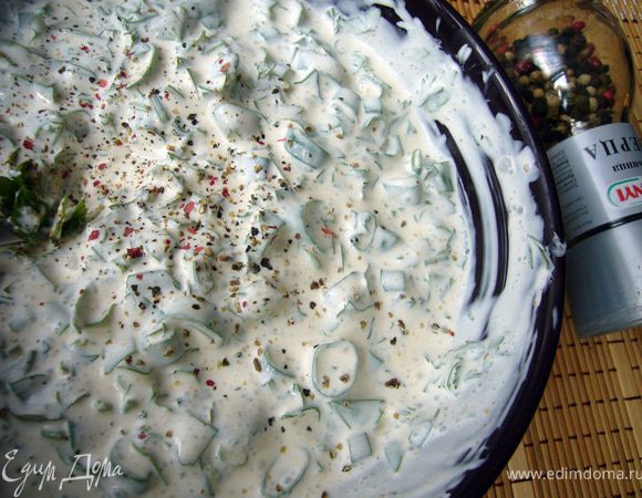 Фаршированные кабачки под овощной шубкой продолжают запекаться, а мы в это время готовим сметанную заливку. Смешаем сметану со сливками до однородности, добавим мелко рубленную зелень, итальянские травы и чуть подсолим.