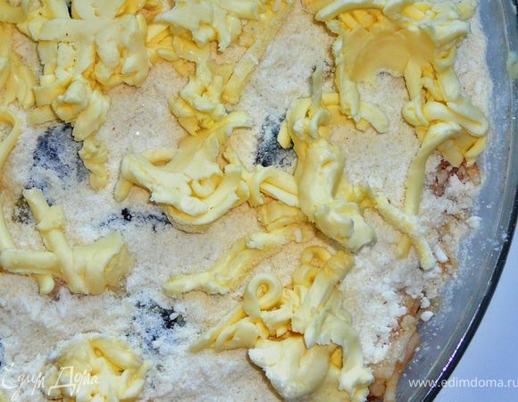 Натереть на крупной терке холодное сливочное масло и выложить по всей поверхности пирога.