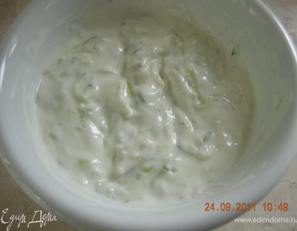 Пока тефтели жарятся, приготовим дзадзики. На мелкой терке натереть огурец, отжать жидкость и удалить ее. К огурцу добавить йогурт, соль, перец, раздавленный чеснок и мелко порубленную мяту.