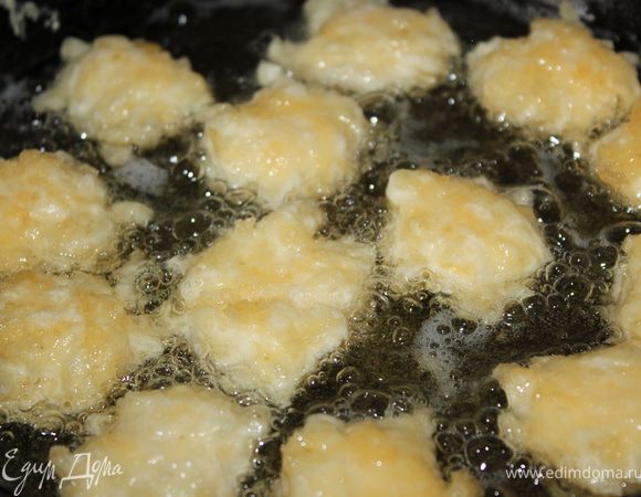 Духовку предварительно нагреть до 160 градусов. Налить масло в сковороду, нагреть на среднем огне и аккуратно, при помощи чайной ложки, выкладывать сырную смесь в горячее масло. Жарить 1-2 минуты, до золотистого цвета. Так пережарить все сырные шарики.