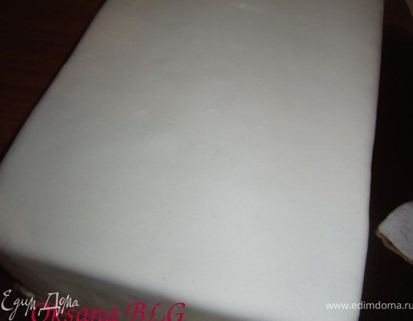 Охлажденный и выровняный торт покрыть мастикой.