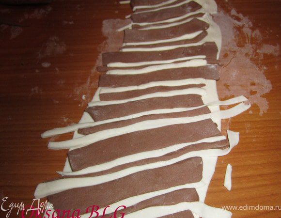 Вырезать полоски из белой и шоколадной мастики, выложить на раскатанную мастику.